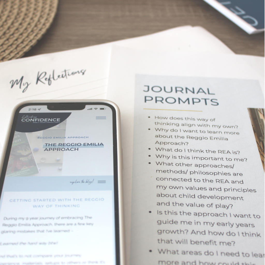 Journal prompts on aa paper with a phone next to it with the blog, The Reggio Emilia Approach, on screen.